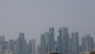 A picture shows a moored dhow with the Doha skyline in the background on a hot and humid summer day on August 6, 2025. (Photo by Karim JAAFAR / AFP)
