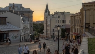 People walk on the Andriivskyi Descent in the Podil neighborhood, in downtown Kyiv, on August 16, 2025, amid the Russian invasion of Ukraine. (Photo by Roman Pilipey / AFP)