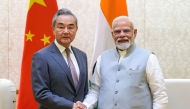 This handout photograph taken on August 19, 2025 and released by the Indian Press Information Bureau (PIB) shows India's Prime Minister Narendra Modi shaking hands with Beijing's Foreign Minister Wang Yi during a bilateral meeting in New Delhi on August 19, 2025. (Photo by Indian Press Information Bureau (PIB) / AFP) 
