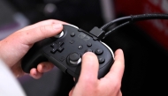 A gamer holds a controller, at the Nintendo Switch 2 booth, during the Gamescom video games trade fair at the Trade Fair Center in Cologne, western Germany on August 20, 2025. (Photo by Ina Fassbender / AFP)