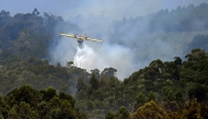 (Files) A firefighter airplane battles a wildfire near the village of Vilaboa, northwestern Spain on August 22, 2025. (Photo by Miguel Riopa / AFP)  