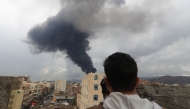 A photojournalist takes a picture of smoke after an Israeli air strike on Yemen's capital Sanaa on August 24, 2025. (Photo by Mohammed Huwais / AFP)
