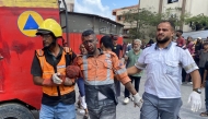 Graphic content / Palestinian medics bring an injured civil defence member at Nasser Hospital in Khan Yunis, in the southern Gaza Strip, on August 25, 2025, following Israeli air strikes.  Israeli strikes on the hospital killed at least 15 people on August 25, including four journalists and one civil defence member. (Photo by AFP)