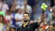 Serbia's Novak Djokovic prepares to throw signed tennis balls to fans after winning his men's singles first round tennis match against USA's Learner Tien in New York City, on August 24, 2025. (Photo by Charly Triballeau / AFP)