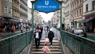 A family exits the metro station onto Karl Marx Strasse in the district of Neukoelln, Berlin on August 28, 2025. Photo by Odd ANDERSEN / AFP