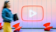 In this file photo taken on April 23, 2025 shows a woman walking by a YouTube logo in San Bruno, California. Photo by JOSH EDELSON / AFP