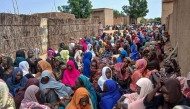 Sudanese gather to receive free meals in El-Fasher, a city besieged by Sudan's paramilitary Rapid Support Forces (RSF) for more than a year, in Darfur region, on August 11, 2025. (Photo by AFP)