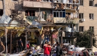 Local residents embrace each other next to a damaged residential building following an air attack in Zaporizhzhia on August 30, 2025. (Photo by Marina Moiseyenko / AFP)