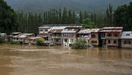 Partially submerged houses are pictured along the banks of the river Jhelum following heavy rains in Srinagar on August 28, 2025. Photo by Tauseef MUSTAFA / AFP.
