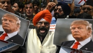 Members of a trades association holding a poster of US President Donald Trump shout slogans during a protest against the recent tariff hikes imposed by the US on India in New Delhi on August 30, 2025. (Photo by Arun SANKAR / AFP)
