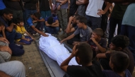 Palestinians mourn by the shrouded body of a relative killed in Israeli strikes on Gaza City the previous night, at Al-Shifa hospital on September 1, 2025. (Photo by BASHAR TALEB / AFP)
