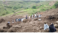 This handout image made available by the Sudan Liberation Movement/Army (SLM), on September 2, 2025, shows people inspecting the debris after a landslide devastated the village of Tarasin in Sudan's Jebel Marra area. (Photo by Sudan Liberation Movement /Army / AFP)
