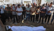 Palestinians pray by the shrouded body of a person killed in Israeli strikes on Gaza City at dawn, at the Al-Shifa hospital on September 2, 2025. (Photo by Omar AL-QATTAA / AFP)
