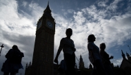Pedestrians walk past the Elizabeth Tower, commonly known by the name of the clock's bell 