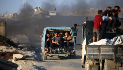 Palestinians fleeing south, ride vehicles with their belongings, on the coastal road near the Nuseirat refugee camp in the central Gaza Strip, on August 5, 2025. (Photo by Eyad Baba / AFP)