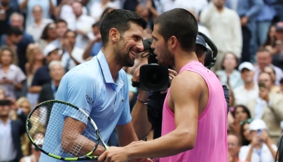 Spain's Carlos Alcaraz and Serbia's Novak Djokovic (L) hug at the net after Alcaraz's victory on September 5, 2025. (Photo by Timothy A. Clary / AFP)
 