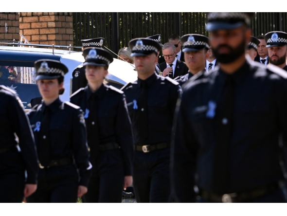 Australia's Prime Minister Anthony Albanese (C) pays his respects as the coffin of police officer Senior Constable Vadim de Waart-Hottart leaves the Victoria Police Academy chapel. (Photo by William West / AFP)