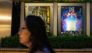 A woman walks past the poster of Japanese movie 