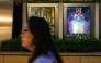 A woman walks past the poster of Japanese movie 