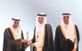 Minister of Labour, H E Dr Ali bin Samikh Al Marri, looks on as QNB official receives an award for supporting national employment during the event.
