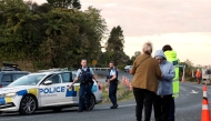 Police officers and locals stand near a roadblock where a police shootout occurred near the town of Piopio, located in New Zealand痴 Waikato region on September 8, 2025. Photo by DJ MILLS / AFP