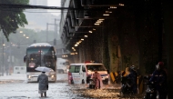 In this photo taken on July 22, 2025, pedestrians wade through a flooded street caused by heavy rains in Manila. Photo by Ted ALJIBE / AFP