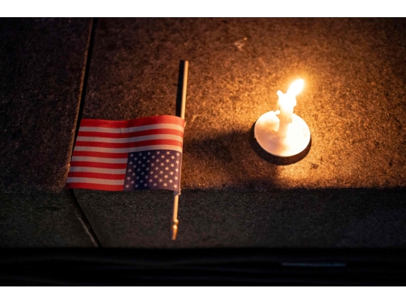 A US flag and a candle sit on a step during a candlelight vigil and prayer event for Turning Point USA Founder Charlie Kirk on September 10, 2025 in Seattle, Washington. David Ryder/Getty Images/AFP 