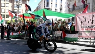 Pro-Palestinians protesters demonstrate as a cyclist competes during the 18th stage of the Vuelta a Espana, yesterday. 