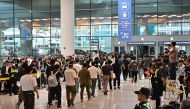 South Korean workers arrive at Incheon International Airport in Incheon on September 12, 2025, after the touch down of a specially chartered Korean Air Boeing 747-81 (KE9036) bringing hundreds of South Korean workers back from Atlanta after their detention in a US immigration raid at a Hyundai-LG plant in Ellabell, Georgia. (Photo by Anthony WALLACE / AFP)