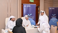 Officials and Qatari graduates during the event. 