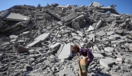 A Palestinian girl searches the rubble of al-Ghafari tower after its destruction by Israeli airstrikes in Gaza City on September 15, 2025. (Photo by Omar AL-QATTAA / AFP)
