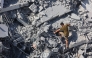 A Palestinian youth climbs the rubble of al-Ghafari tower after its destruction by Israeli airstrikes in Gaza City on September 15, 2025. Photo by Omar AL-QATTAA / AFP