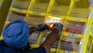 A worker grabs products from a bin at Amazon Fulfillment Center SCK6 in Tracy, California. Photo credit: Jungho Kim/For The Washington Post

