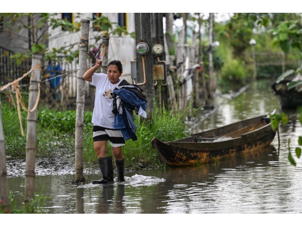 In this photo taken on September 15, 2025, a resident wades through a flooded area in Calumpit, Bulacan. Photo by Jam STA ROSA / AFP