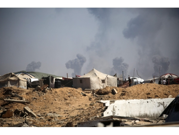 Tents of displaced Palestinians stand in the Nuseirat refugee camp in the central Gaza Strip, as plumes of smoke rise during Israeli bombardment above Gaza City, on September 19, 2025. (Photo by Eyad BABA / AFP)

