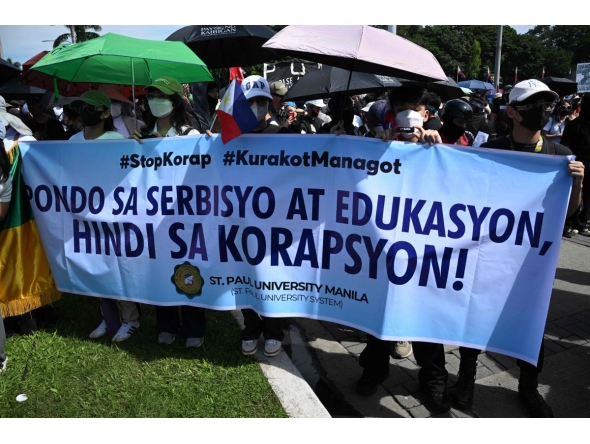 Protesters hold a banner which reads 