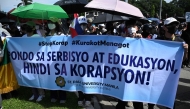 Protesters hold a banner which reads 