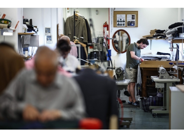 Apprentice tailor Charlie makes adjustments to a jacket at Henry Poole & Co on Savile Row in London on August 12, 2025. (Photo by Henry Nicholls / AFP)