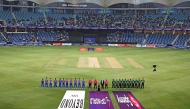 Indian and Pakistani players stand for their national anthem at the start of the Asia Cup 2025 Super Four Twenty20 international cricket match between India and Pakistan at the Dubai International Stadium in Dubai on September 21, 2025. (Photo by Fadel SENNA / AFP)
