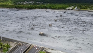 An overview shows flowing mud and floodwaters after a barrier lake burst and caused parts of the bridge over Mataian Creek be destroyed in Hualien on September 24, 2025. (Photo by Taiwan's Central News Agency (CNA) / AFP)