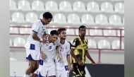 Al Kharaitiyat players celebrate after scoring a goal.