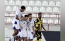 Al Kharaitiyat players celebrate after scoring a goal.