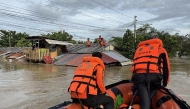 This handout photo taken on September 26, 2025 and released on September 27 by the Philippine Coast Guard shows coast guard personnel rescuing residents from their flooded house at the height of Severe Tropical Storm Bualoi, at a village in Ormoc City, Leyte province. (Photo by Handout / Philippine Coast Guard (PCG) / AFP)