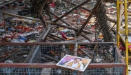 A portrait of actor-turned-politician Vijay is seen near the scattered shoes following a stampede during his political rally in the Karur district, on September 28, 2025. (Photo by AFP)