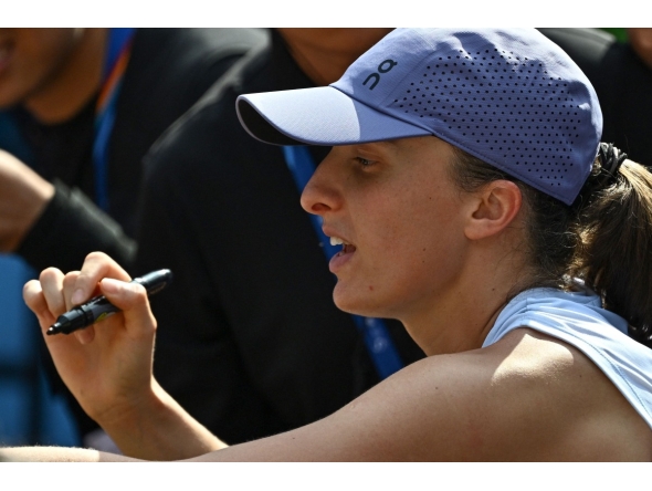 Poland's Iga Swiatek signs autographs for fans after her women's singles match against Colombia痴 Camila Osorio at the China Open tennis tournament in Beijing on September 29, 2025. (Photo by Pedro Pardo / AFP)