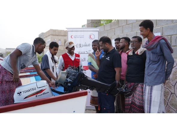 Beneficiaries receiving boats provided by the QRCS.