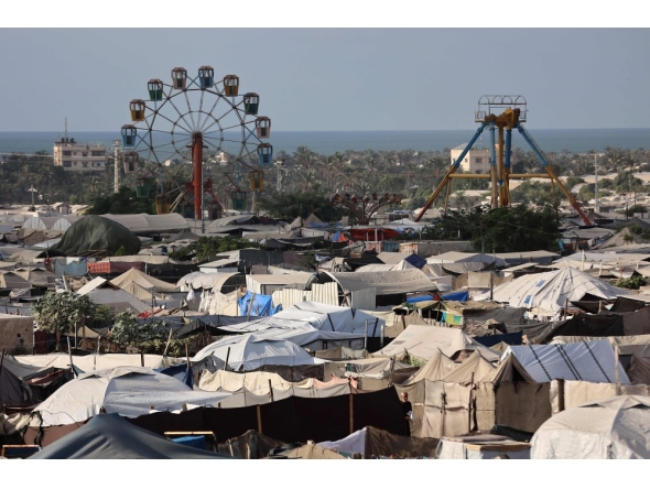 An idle ferris wheel stands near tents at a camp for displaced people in Khan Yunis in the southern Gaza Strip, on September 29, 2025. (Photo by Omar Al-Qattaa / AFP)