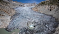 (Files) An aerial photograph taken on August 24, 2023 above Gletsch, in the Swiss Alps shows a hole in the part of the Rhone Glacier revealing its glacial lake due to the melting of the glacier.  (Photo by Fabrice Coffrini / AFP)