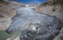 (Files) An aerial photograph taken on August 24, 2023 above Gletsch, in the Swiss Alps shows a hole in the part of the Rhone Glacier revealing its glacial lake due to the melting of the glacier.  (Photo by Fabrice Coffrini / AFP)