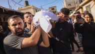 Palestinians carry the body of a man killed in an Israeli strike, during a funeral procession outside al-Aqsa Martyrs hospital in Deir el-Balah in the central Gaza Strip, on October 1, 2025. (Photo by BASHAR TALEB / AFP)
